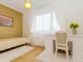 Dormitorio con paredes doradas, cama blanca y escritorio. Los colores que combinan con el amarillo en paredes son el blanco y los tonos tierra, creando un ambiente cálido y luminoso.
