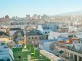 Vista aérea de tejados y edificios de una ciudad española bajo un cielo azul claro.