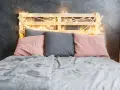 Cabecero de palets ideas: cama con cojines rosas y grises, manta gris y luces cálidas.