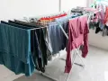 Tendedero desplegado con ropa de varios colores, una solución práctica para tender la ropa en un piso sin terraza.