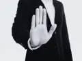 Mano extendida en señal de alto, con un traje oscuro. Representa el derecho de reversión, un límite claro.
