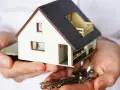 Manos sostienen una maqueta de casa y llaves. ¿Puedo vender mi casa sin consentimiento de mis hijos?