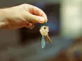 Mano sosteniendo llaves. Podrían denunciarme por no pagar un mes de alquiler y perder mi hogar.