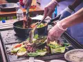 Cocina al aire libre, carne y verduras en plancha. Cumpliendo la normativa barbacoas Catalunya para disfrutar de la comida.