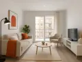 Salón moderno y luminoso. Sofá beige, mesa de centro, sillón, TV y planta. ¡Ideal para cuando pueda alquilar mi primera vivienda!