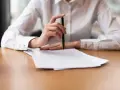 Mano con bolígrafo sobre papeles, revisando documentos. Quizás para resolver el lío de que he heredado una casa sin escrituras.