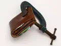 Cartera de cuero apretada en una prensa. El heredero no paga gastos de vivienda, el dinero está bajo presión.