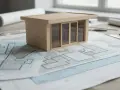 Maqueta de casa moderna sobre planos arquitectónicos, mostrando el concepto de **que es suelo urbano** y su desarrollo.