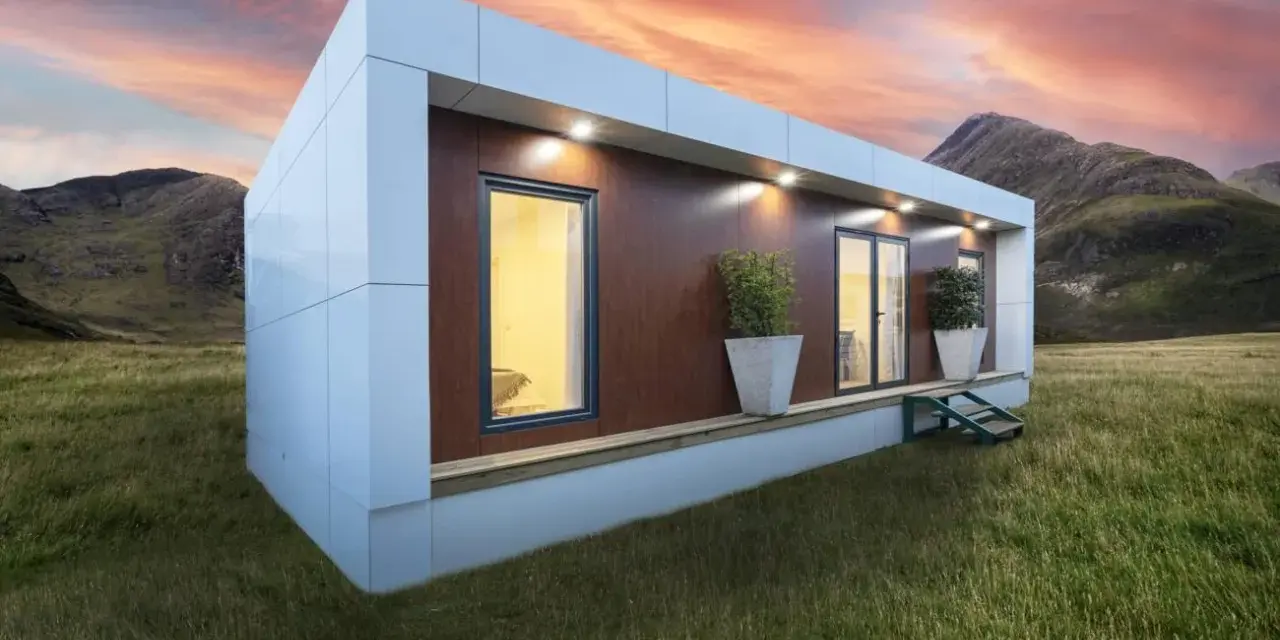 Casa moderna en campo con montañas al atardecer. Obtén tu licencia para instalar mobil home y vive tu sueño.