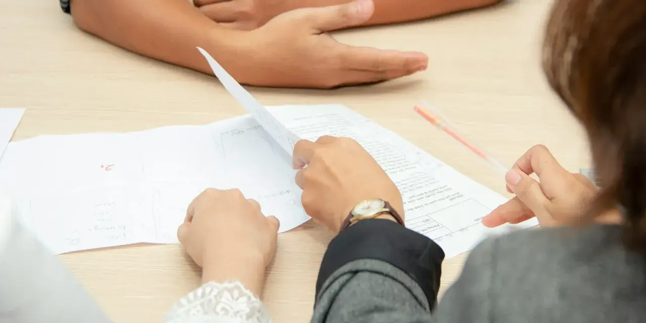 Personas revisando documentos, discutiendo cómo comprar casa sin escrituras.