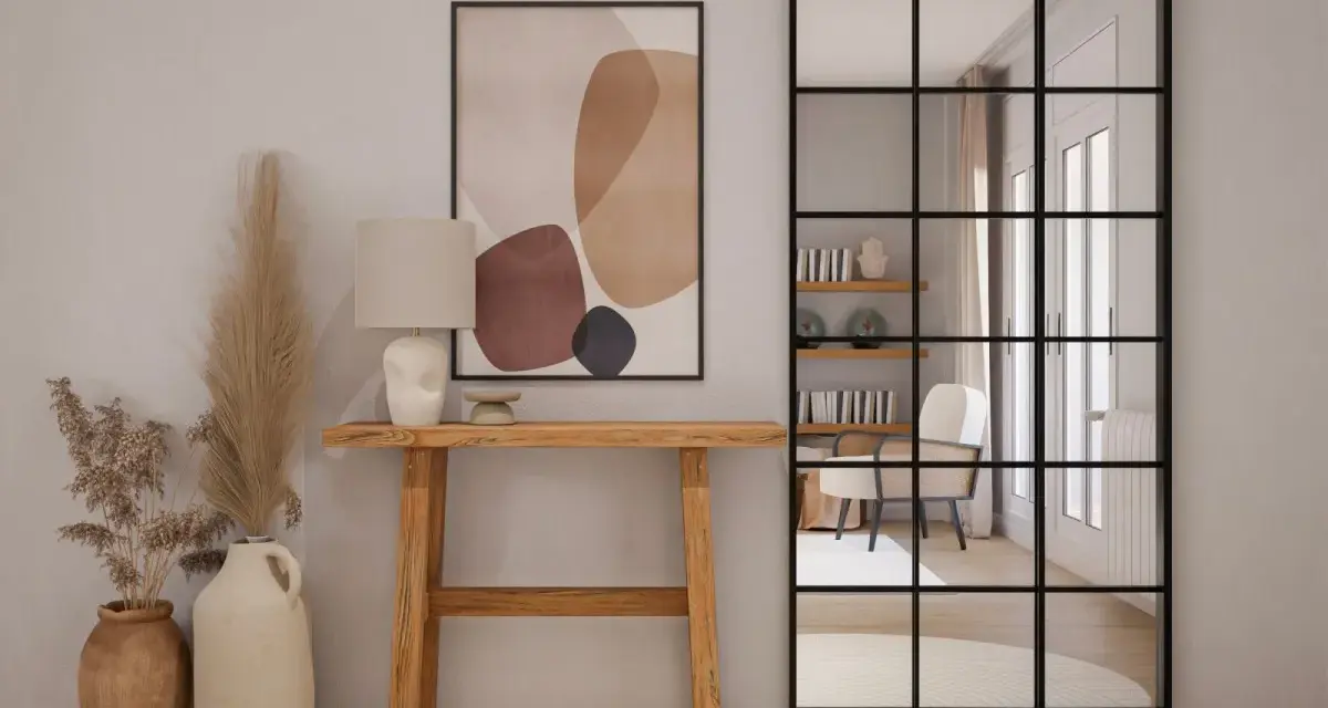 Una elegante entrada para una casa con consola de madera, lámpara, arte abstracto y espejo industrial.