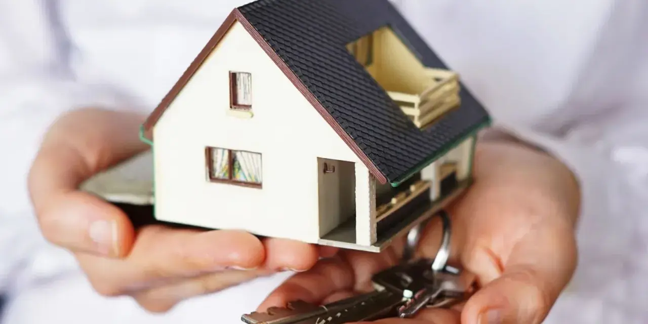Manos sostienen una maqueta de casa y llaves. ¿Puedo vender mi casa sin consentimiento de mis hijos?