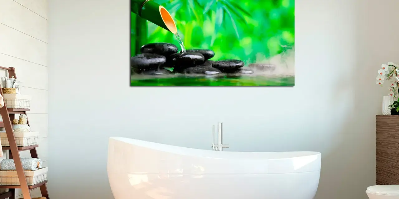 Un cuadro con bambú y piedras de spa, ideal para crear ideas de cuadros para baños relajantes y zen.