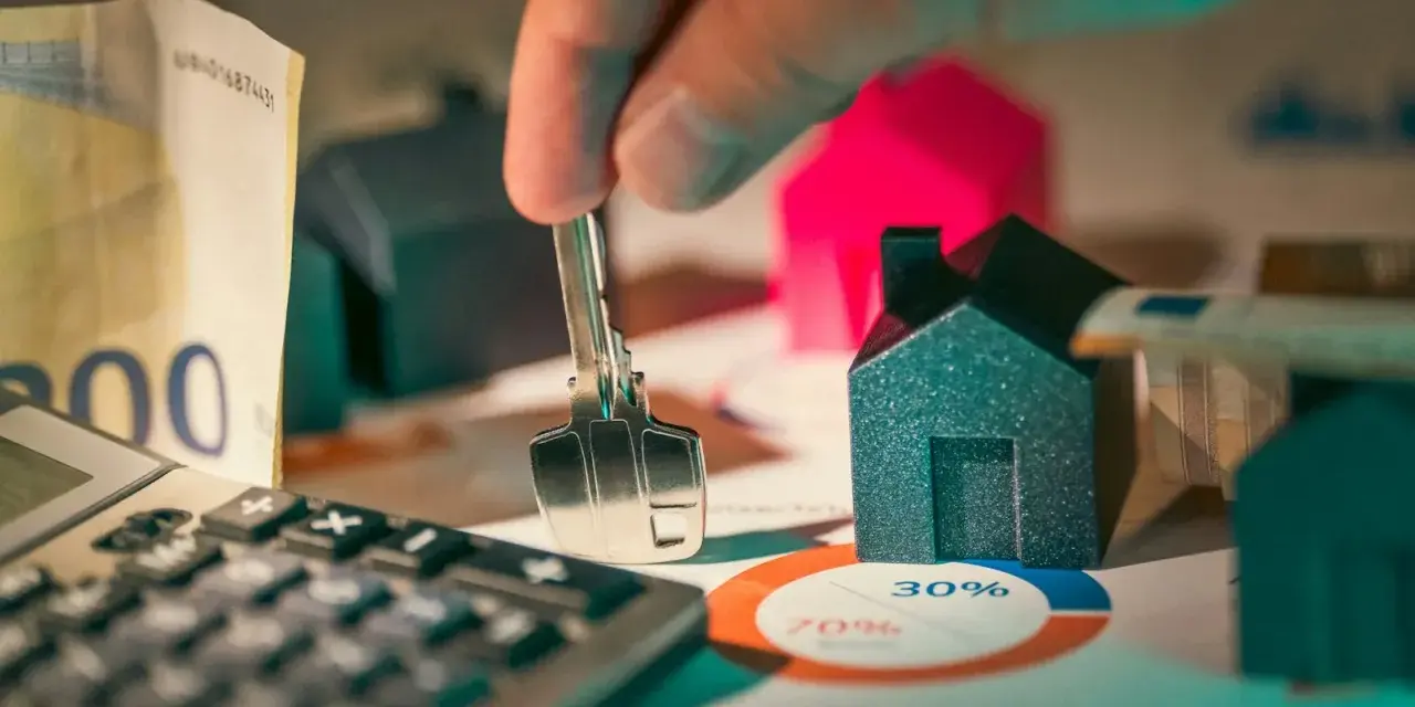Llaves, dinero y casas en miniatura sobre un gráfico. ¿Es posible empadronarse sin contrato de alquiler?