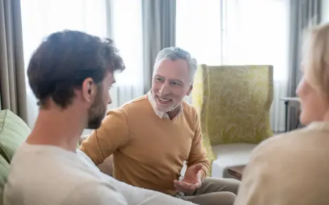 Padre explica a su hijo cómo dejar vivienda en usufructo. Conversación familiar en un salón acogedor.