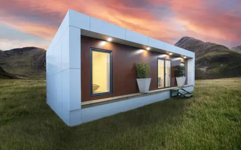 Casa moderna en campo con montañas al atardecer. Obtén tu licencia para instalar mobil home y vive tu sueño.
