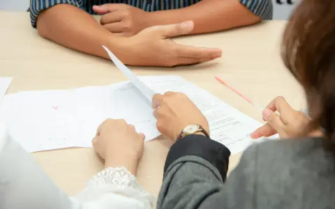 Personas revisando documentos, discutiendo cómo comprar casa sin escrituras.