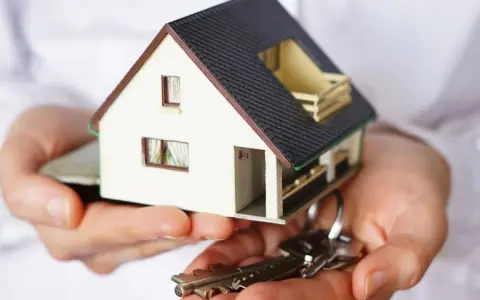 Manos sostienen una maqueta de casa y llaves. ¿Puedo vender mi casa sin consentimiento de mis hijos?