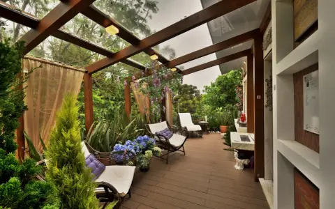 Relájate en estos patios con encanto, rodeado de vegetación exuberante y muebles cómodos bajo un techo de cristal.