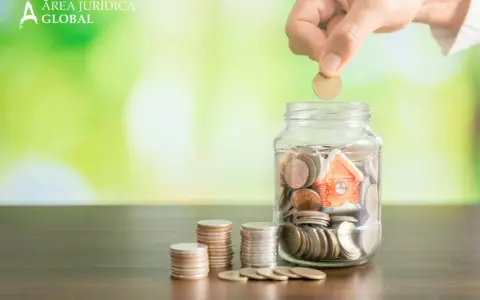 Mano deposita moneda en alcancía con casa, pensando qué pasa si no pago el último mes de alquiler.