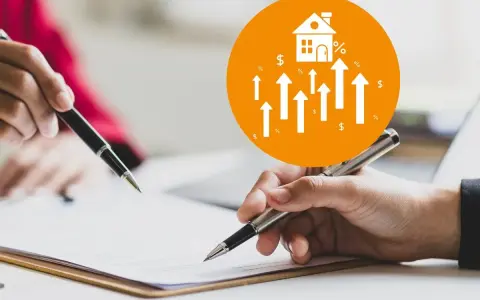Manos firmando un documento para el cambio titularidad vivienda por donación. Icono de casa con flechas ascendentes.