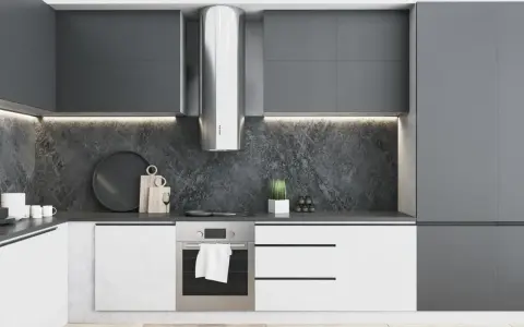Moderna cocina blanca y gris oscuro con campana extractora de acero inoxidable, encimera de piedra y armarios minimalistas.