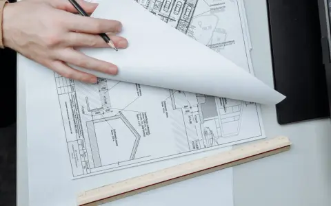 Manos revisando planos de construcción, un detalle que sugiere que se puede escriturar sin cédula de habitabilidad.