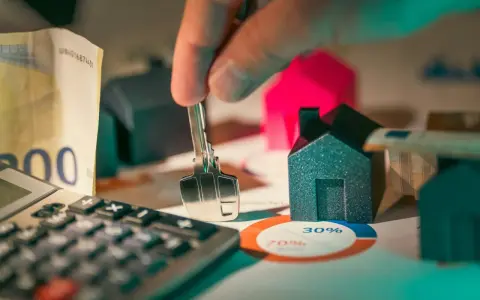 Llaves, dinero y casas en miniatura sobre un gráfico. ¿Es posible empadronarse sin contrato de alquiler?