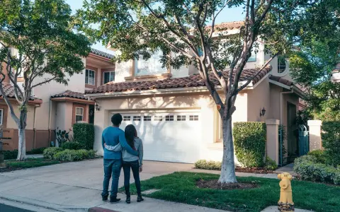 Pareja joven contempla su nueva casa a nombre de dos personas no casadas, un futuro compartido.