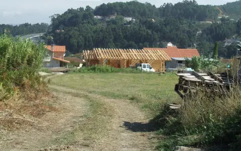 Terreno rural con construcción de madera, casas y vegetación. Se observa un camino de tierra y una posible servidumbre de acueducto en el paisaje.