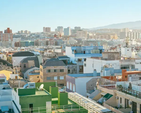 Vista aérea de tejados y edificios de una ciudad española bajo un cielo azul claro.