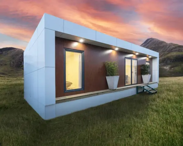 Casa moderna en campo con montañas al atardecer. Obtén tu licencia para instalar mobil home y vive tu sueño.