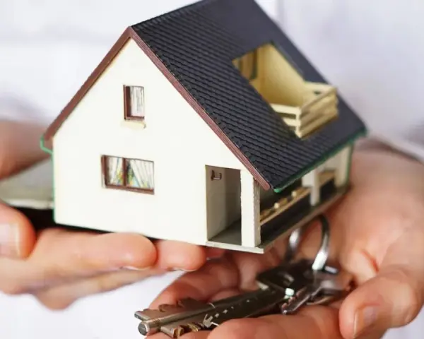 Manos sostienen una maqueta de casa y llaves. ¿Puedo vender mi casa sin consentimiento de mis hijos?