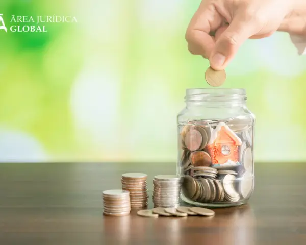 Mano deposita moneda en alcancía con casa, pensando qué pasa si no pago el último mes de alquiler.