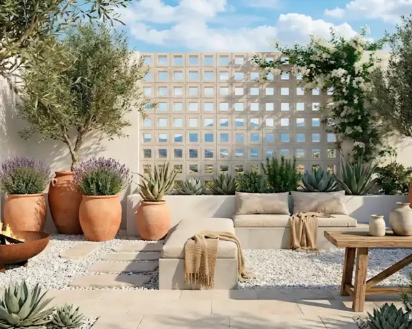 Terraza con asientos, plantas en macetas, un fuego y una pared de bloques decorativa.