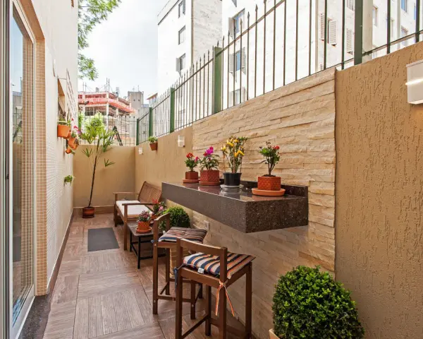 Un balcón acogedor con muebles de madera, plantas y un estante de granito. Ideal para disfrutar de pequeños patios.