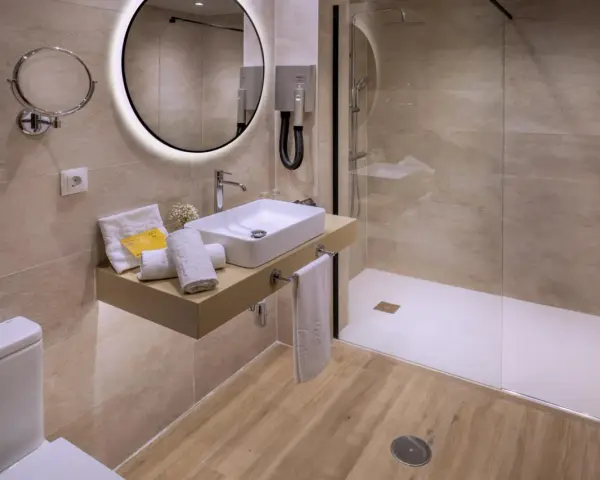 Baño moderno con ducha, lavabo y WC. Se podría pensar que para cambiar bañera por ducha hace falta licencia de obra, pero aquí ya está hecho.