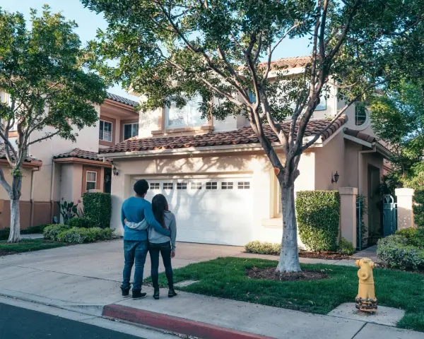 Pareja joven contempla su nueva casa a nombre de dos personas no casadas, un futuro compartido.