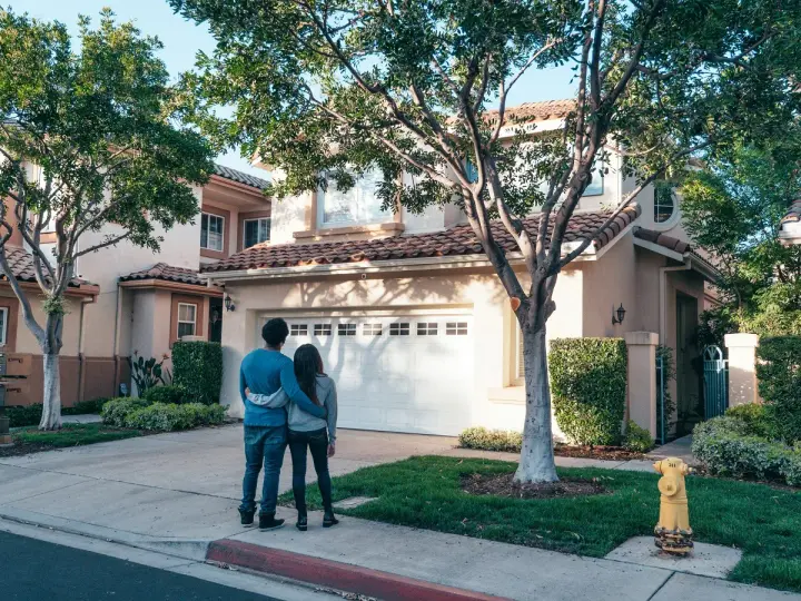 Pareja joven contempla su nueva casa a nombre de dos personas no casadas, un futuro compartido.