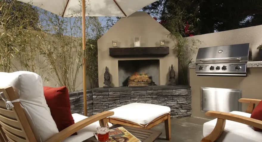 Un patio privado con chimenea, parrilla y cómodos asientos bajo sombrilla. Ideal para techar patio comunitario de uso privativo.