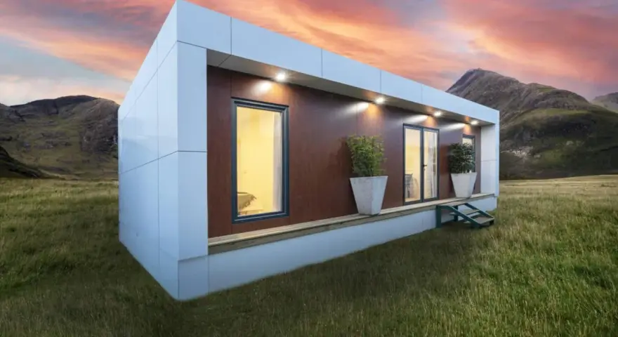 Casa moderna en campo con montañas al atardecer. Obtén tu licencia para instalar mobil home y vive tu sueño.