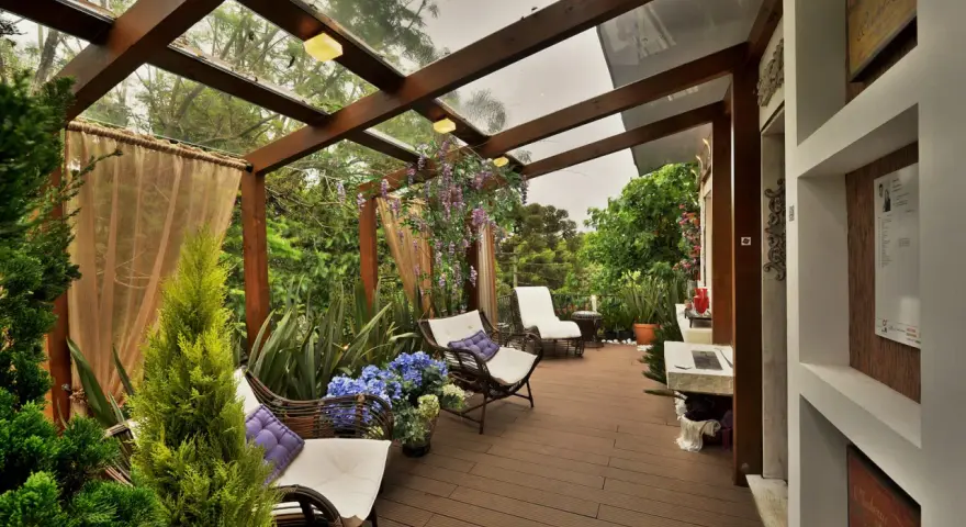 Relájate en estos patios con encanto, rodeado de vegetación exuberante y muebles cómodos bajo un techo de cristal.