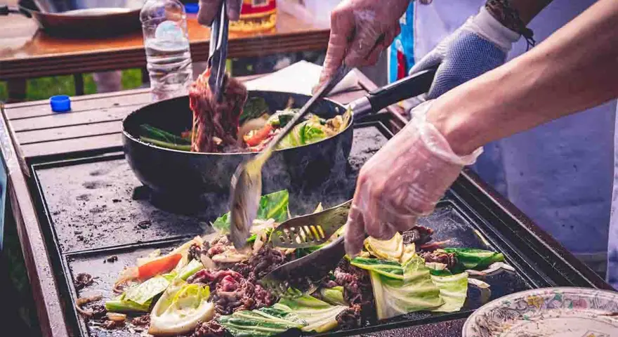 Cocina al aire libre, carne y verduras en plancha. Cumpliendo la normativa barbacoas Catalunya para disfrutar de la comida.