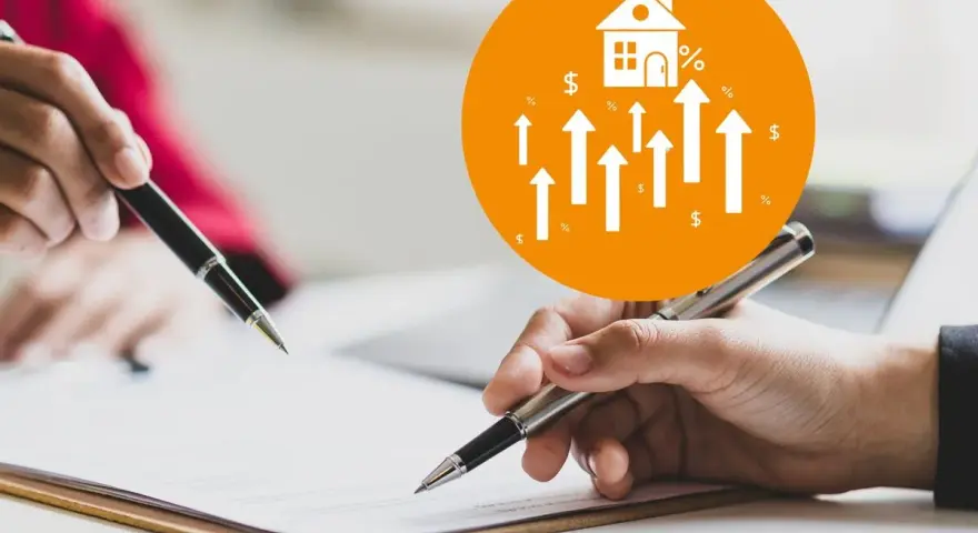 Manos firmando un documento para el cambio titularidad vivienda por donación. Icono de casa con flechas ascendentes.