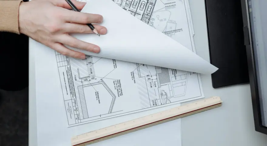 Manos revisando planos de construcción, un detalle que sugiere que se puede escriturar sin cédula de habitabilidad.