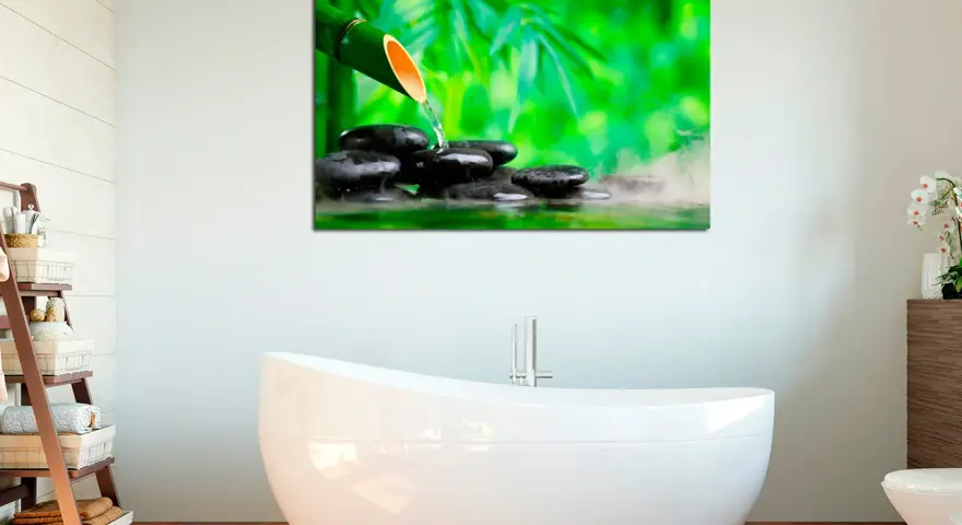 Un cuadro con bambú y piedras de spa, ideal para crear ideas de cuadros para baños relajantes y zen.
