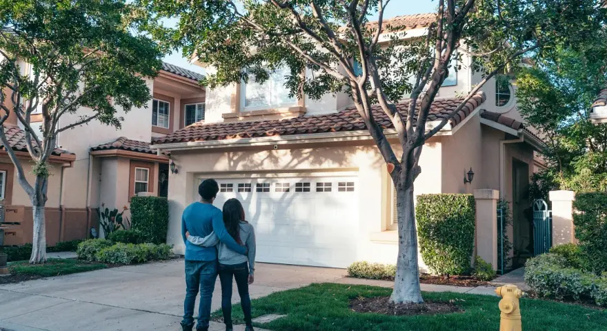 Pareja joven contempla su nueva casa a nombre de dos personas no casadas, un futuro compartido.