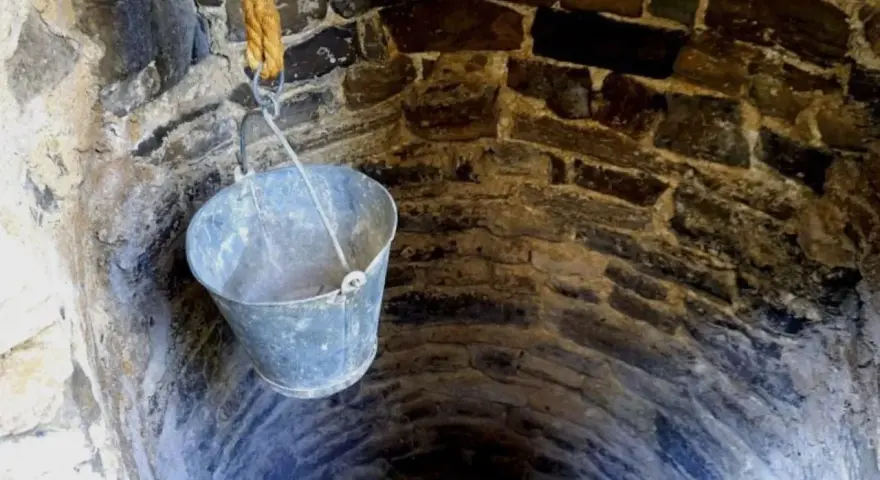 Un cubo cuelga de una cuerda en un pozo de piedra. ¡Qué útil sería si pudiera hacer un pozo en mi parcela!