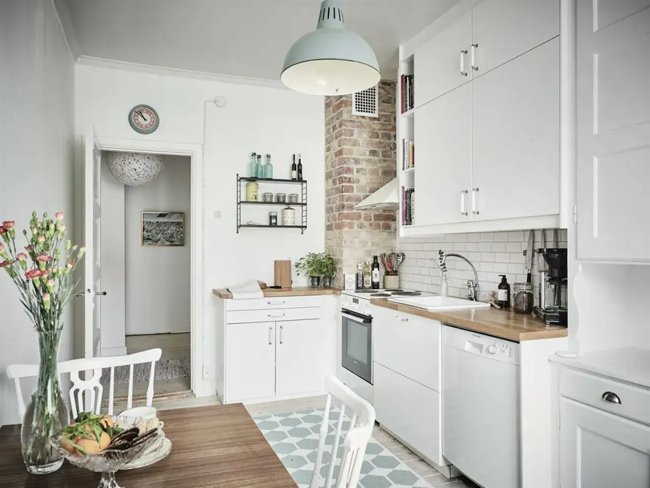 Cocina luminosa con encanto r&uacute;stico. Muebles blancos, ladrillo visto y detalles que sugieren casas que no necesitan permiso de obra.