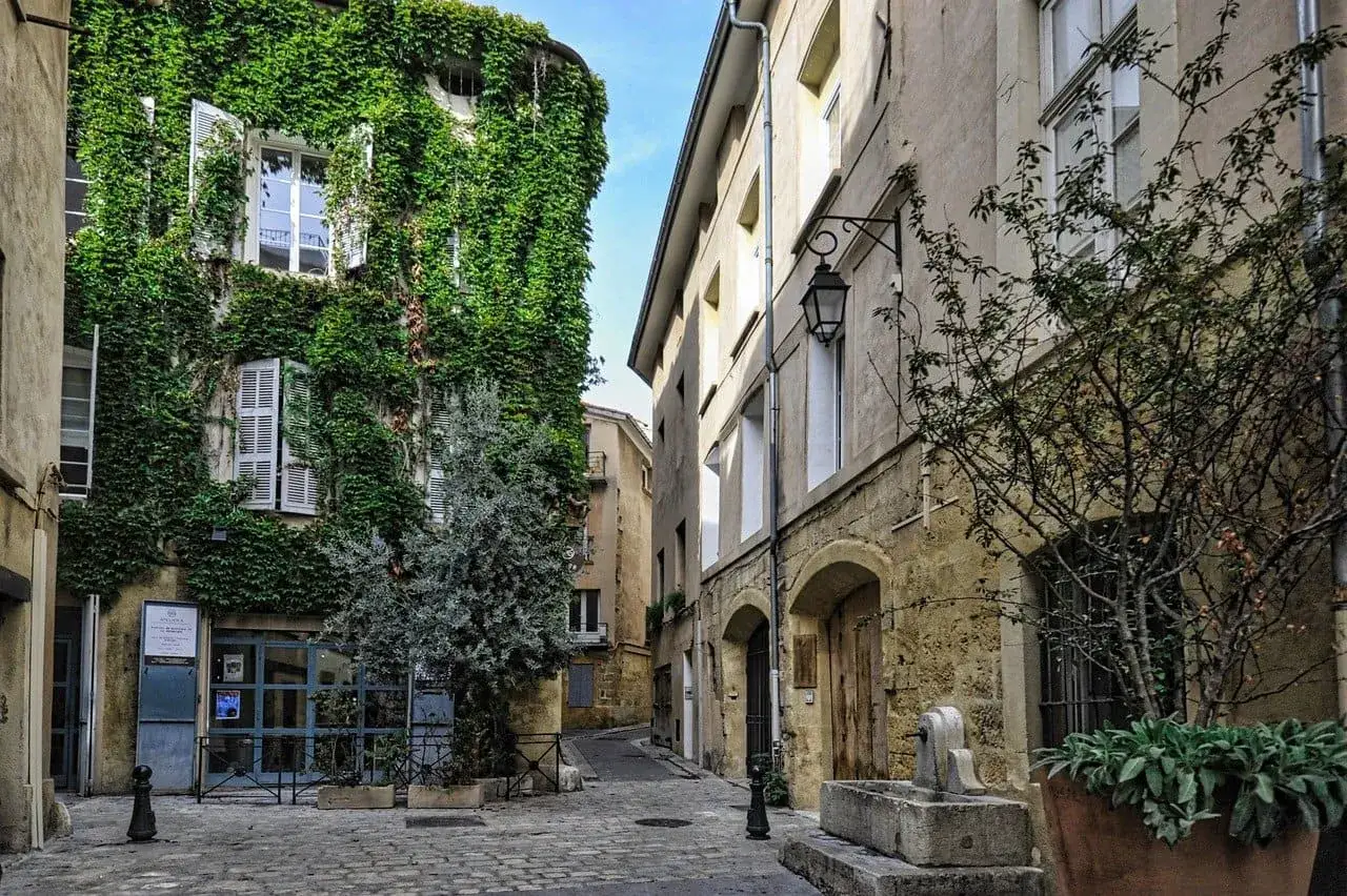 Calle empedrada con casas antiguas. Una fachada est&aacute; cubierta de hiedra. Me pregunto si esta casa sin escrituras que he heredado se parecer&aacute; a esta.